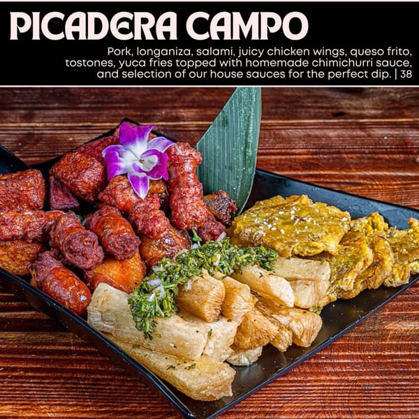 A platter of fried pork, longaniza, chicken wings, queso frito, tostones, and yuca fries with chimichurri.