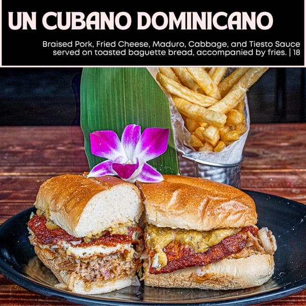 A Cubano Dominicano sandwich with braised pork, fried cheese, maduro, and cabbage, with fries.