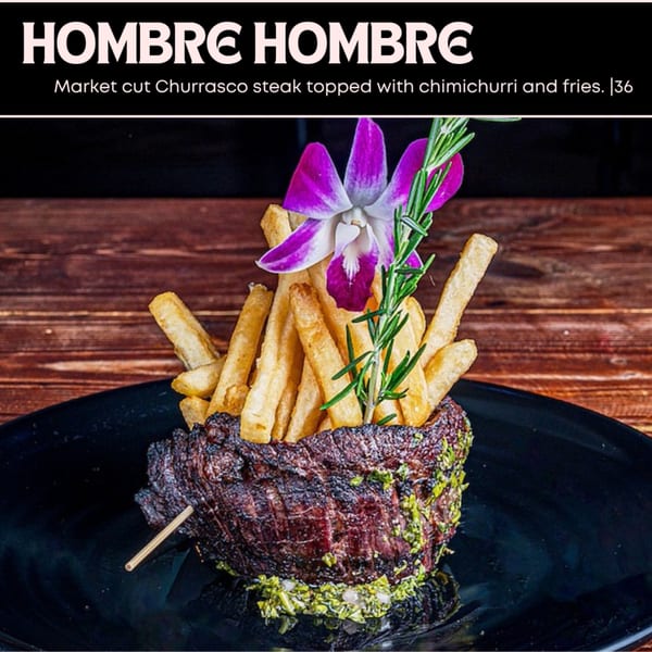 Market cut Churrasco steak topped with chimichurri and fries, garnished with an orchid and rosemary.