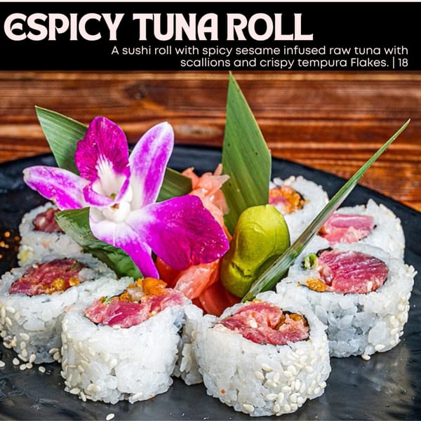 Spicy Tuna Roll with raw tuna, scallions, tempura flakes, garnished with an orchid and ginger.