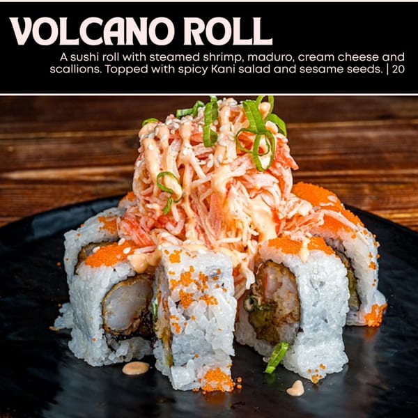 Volcano Roll sushi with steamed shrimp, maduro, cream cheese, scallions, spicy Kani salad, and sesame seeds.