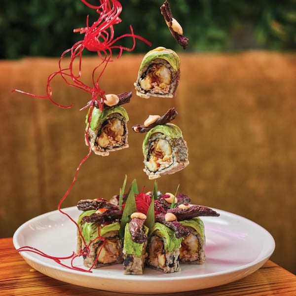 El Tiesto Cafe's sushi rolls with avocado, shrimp, and beef, garnished with red strings.