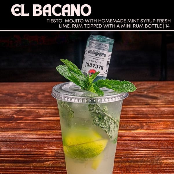 Tiesto Mojito with mint, lime, and a mini Bacardi rum bottle in a plastic cup on a wooden table.