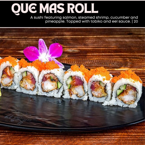 Que Mas Roll sushi with salmon, shrimp, cucumber, pineapple, tobiko, and eel sauce on a black plate.