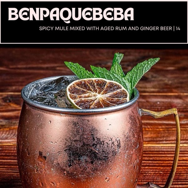 A copper mug filled with ice, a dried lime slice, and fresh mint leaves, on a wooden surface.